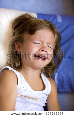 sick child crying while he measures the temperature , soft focus, ,best focus on teeth