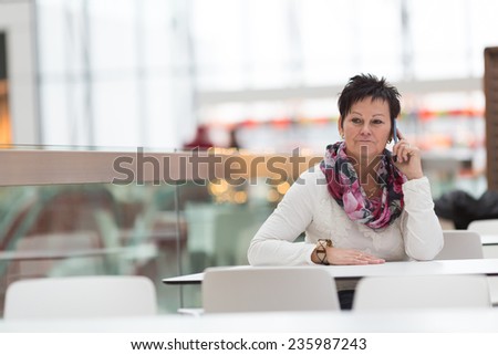 Woman sitting in cafe and calling with mobile phone. Cafe city lifestyle woman on phone. Business concept - businesswoman talking on the phone in restaurant.