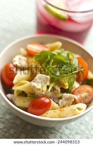 Penne pasta tuna salad with fresh grape tomatoes and arugula
