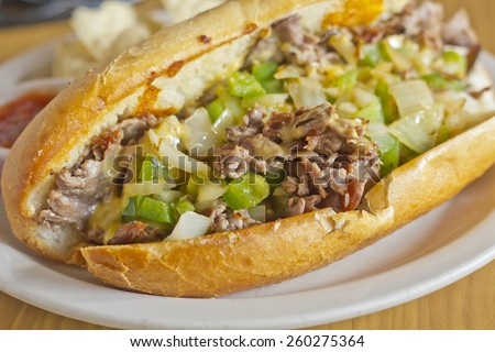 Philly Cheesesteak with diced onions peppers and mushrooms with tortilla chips and salsa on the side