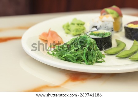 Assorted plate of Japanese sushi demonstrating variety including edamame and seaweed salad