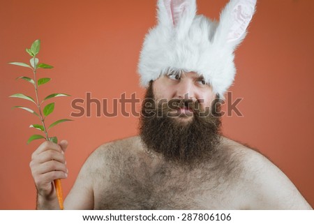 Disapproving man wearing bunny ears and holding carrot