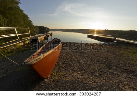 Red canoe on lake shore at dusk in fisheye nature shot