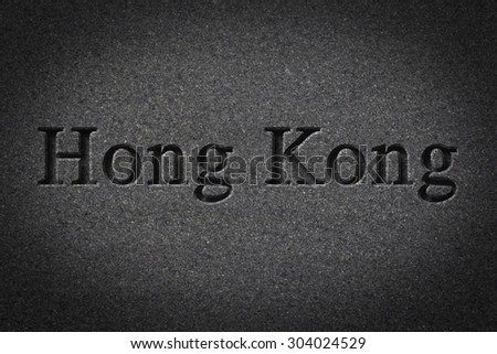 Engraving spelling the city Hong Kongon textured old surface