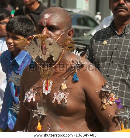 SINGAPORE - JAN 27: Thaipusam festival, a Tamil Hindu devotee takes a pilgrimage with pierced cheeks and hooks on his body  on January 27, 2013 in Singapore