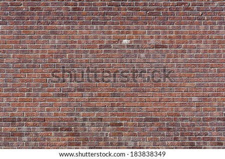 Pocked and stained red brick wall; landscape orientation.