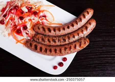 Grilled sausages with easy side dish of sauerkraut and cranberry curls on top