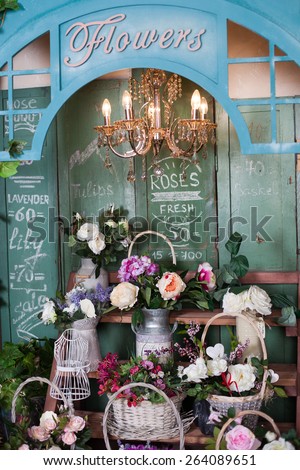 shelves with basket of flowers in a flower shop, peonies, roses, artificial flowers