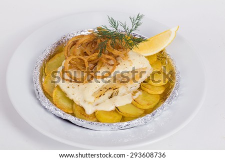 white fish with potatoes, fried onions, dill, lemon in foil isolated on a white background for the menu
