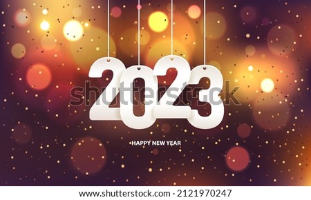 Happy new year 2023. Hanging white paper number with confetti on a colorful blurry background.