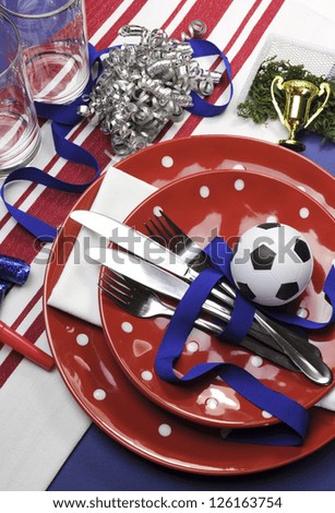 Soccer football celebration party table settings in red, white and blue team colors. Vertical portrait orientation.