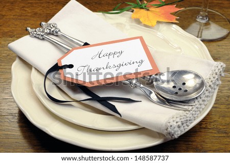 Happy Thanksgiving individual dinner table place setting with best dinnerware and silverware and greeting tag, with autumn flowers.
