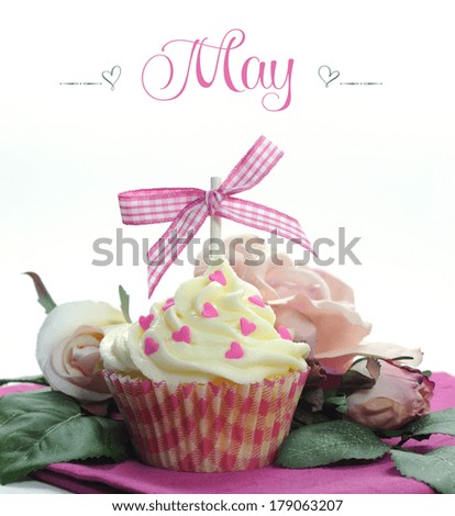Beautiful pink heart or Mothers Day theme cupcake with seasonal flowers and decorations for the month of May with sample text or copy space for your text here.