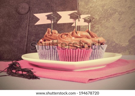 Retro Filter Graduation day pink and purple party cupcakes on plate.