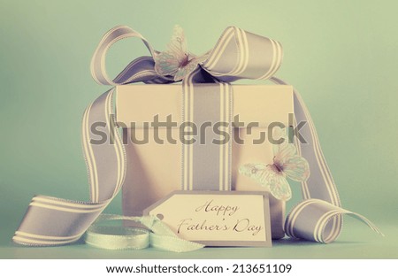 Happy Fathers Day blue butterfly theme gift with greeting gift tag against a blue background with retro vintage style filter.