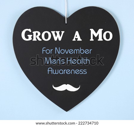 Grow a Mustache message on heart shaped blackboard for November Mens Health Issues Awareness