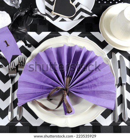 Black and white chevron with purple theme party luncheon table place setting for Melbourne Cup, Australian public holiday, horse race event - overhead view.