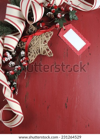 Festive Christmas and Happy Holiday background on dark red vintage recycled wood background with copy space for your text here. Vertical with gift tag.