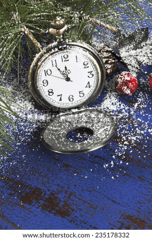 Happy New Year pocket fob watch with five to midnight time and decorations on dark blue rustic distressed vintage wood.