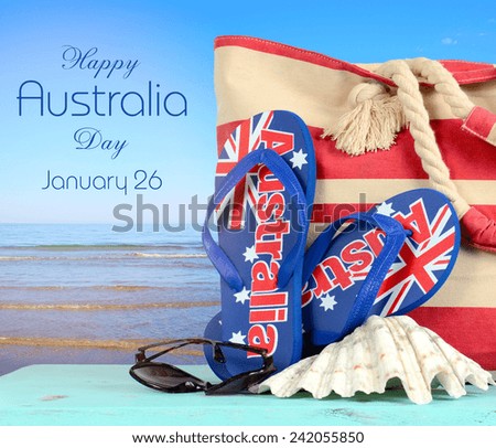 Australian beach scene with Aussie sandals, beach bag, sunglasses and shell with view of blue ocean.