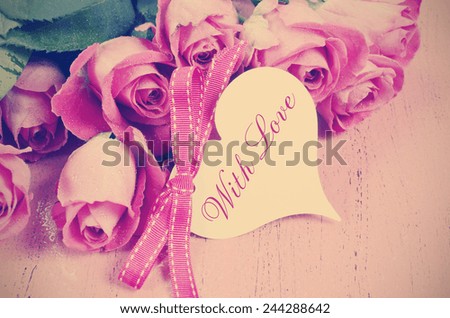 Retro vintage style pink roses on pink wood background for Mothers Day, Valentines Day or International Womens Day, March 8. with heart shape gift tag and sample text.