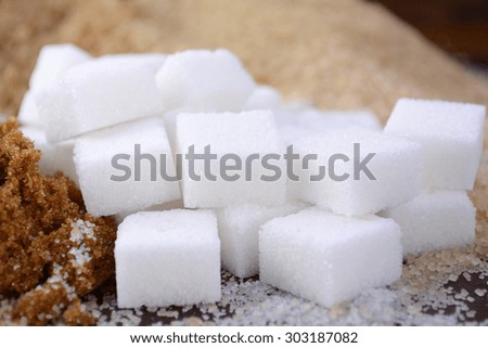 Different types of sugar including white, brown, dark brown, demerara, coffee sugar crystals and sugar cubes.