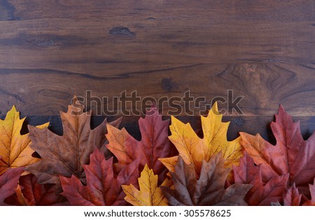Autumn Fall background for Thanksgiving or Halloween with leaves and decorations on rustic wood table with copy space for your text here.
