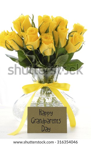 Yellow roses gift in vase with greeting card and sample text for Grandparents Day on white vintage wood table.