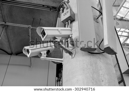 black and white CCTV camera or surveillance operating with electric door in back