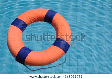 Orange swim ring with deep blue trim floating on water.