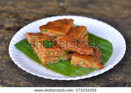 Fried fish-paste balls on banana leaf and paper plate.