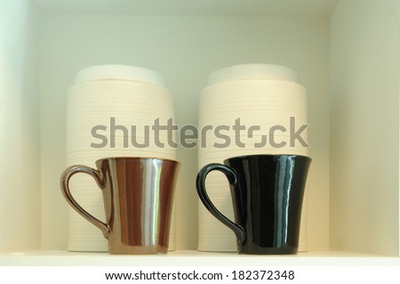 Double coffee-cups on white shelf