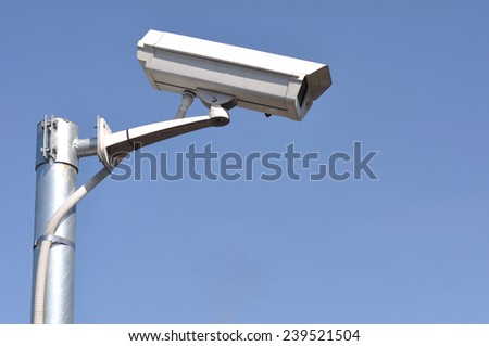 White security camera monitor on iron pole.