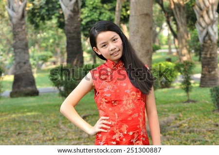 Asia female teenager wear red suit pose for take photo in garden, Chinese New Year traditions