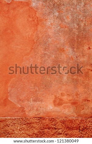 Abstract background of a double textured painted wall with rough stippled plaster below and a smoother textured plaster