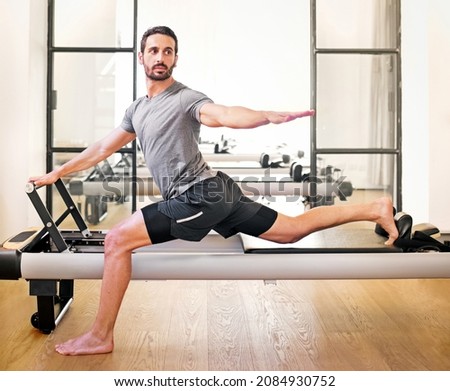 Image, Stock Photo Sportsman using pilates machine under supervision of female trainer