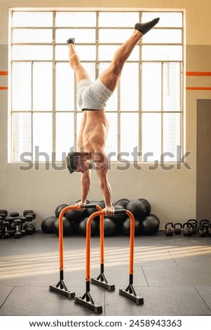 Similar – Image, Stock Photo Strong man performing handstand on sports ground