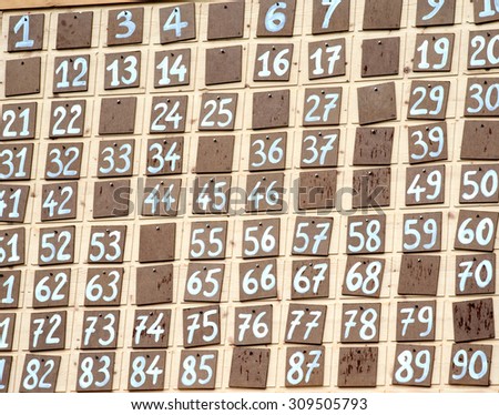 Bingo chart showing numbers already drawn and called on hand painted squares on a board