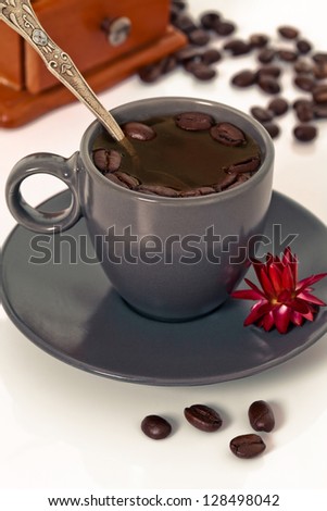 Coffee cup with coffee grinder and orchid flower