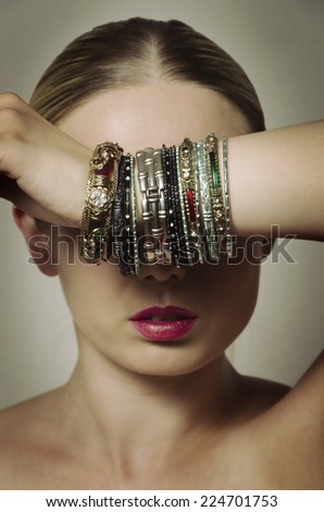 woman covering her eyes with hand with lots of bracelets