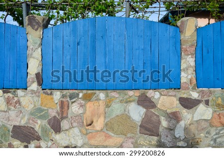 Blue wooden and stone fence, built in traditional Romanian way