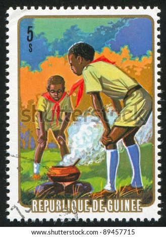 GUINEA CIRCA 1974: stamp printed by Guinea, shows Cooking in camp, circa 1974
