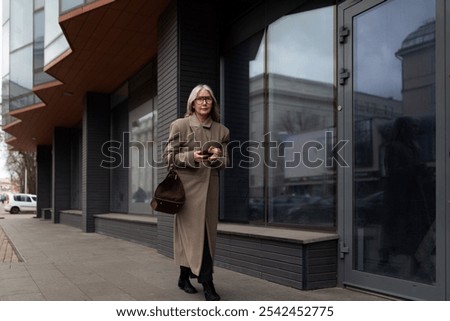 Similar – Image, Stock Photo Stylish businesswoman walking along street in city