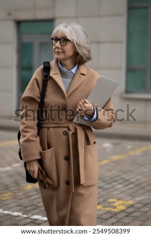 Similar – Image, Stock Photo Stylish businesswoman walking along street in city