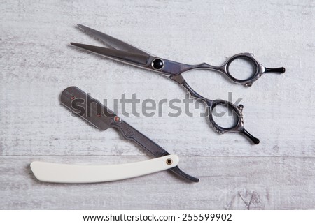 professional barber scissors, tools for cutting, shot with depth of field on light textured background