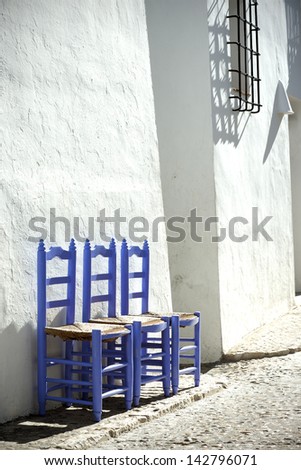 Blue chairs on the background of the white house in Cyprus