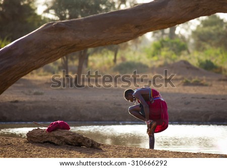 Kenya 2015 Year January 28 .Masai washing feet in water hole in Amboseli