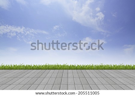 Fresh spring green grass with blue sky and grey tile floor background