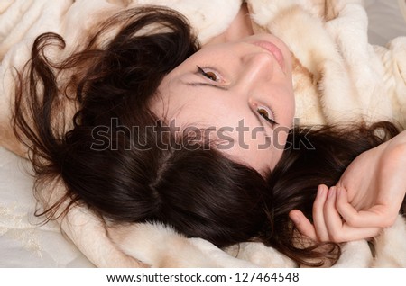 beautiful and sexy young woman laying on the fur coat