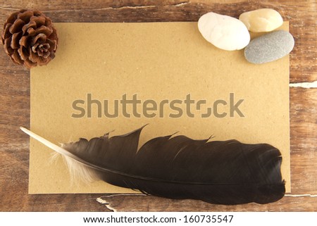Note paper with feather,stones and pine cone